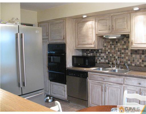 39 Warrenville Road Middlesex, NJ 08846 - Photo 6 of 23 a kitchen with a sink and refrigerator