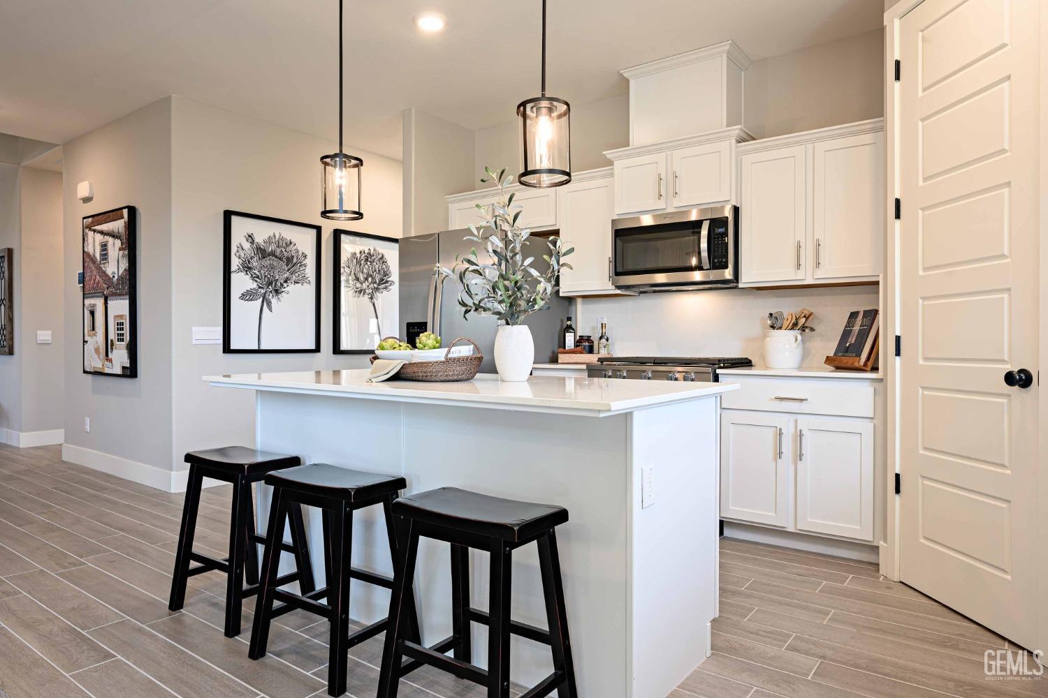 Undisclosed Address Bakersfield, CA 93313 - Photo 2 of 27 a kitchen with white cabinets and stainless steel appliances
