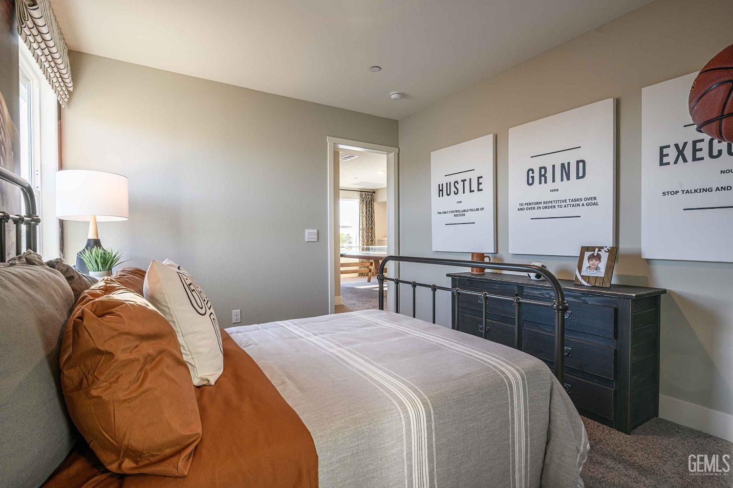 Undisclosed Address Bakersfield, CA 93313 - Photo 22 of 27 a bedroom with a bed and dresser with mirror