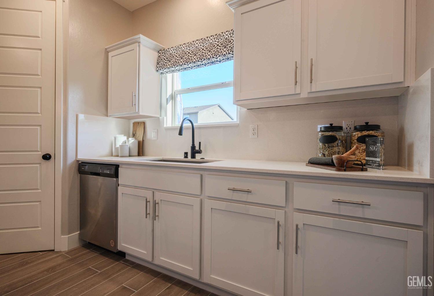 Undisclosed Address Bakersfield, CA 93313 - Photo 4 of 27 a kitchen with white cabinets and a sink