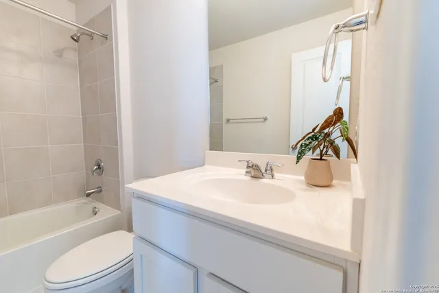 a bathroom with a granite countertop sink a toilet and shower