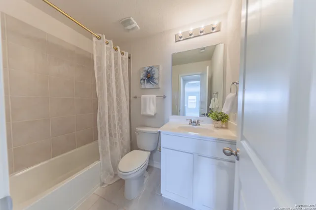 a bathroom with a sink a toilet a mirror and shower