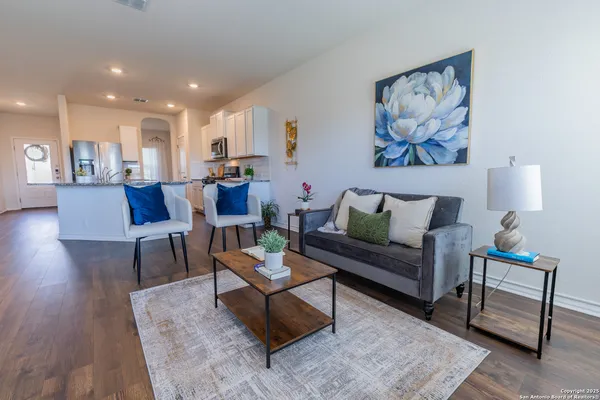 a living room with furniture and a wooden floor