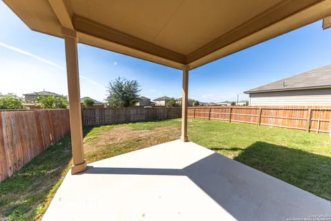 a view of a backyard with wooden fence