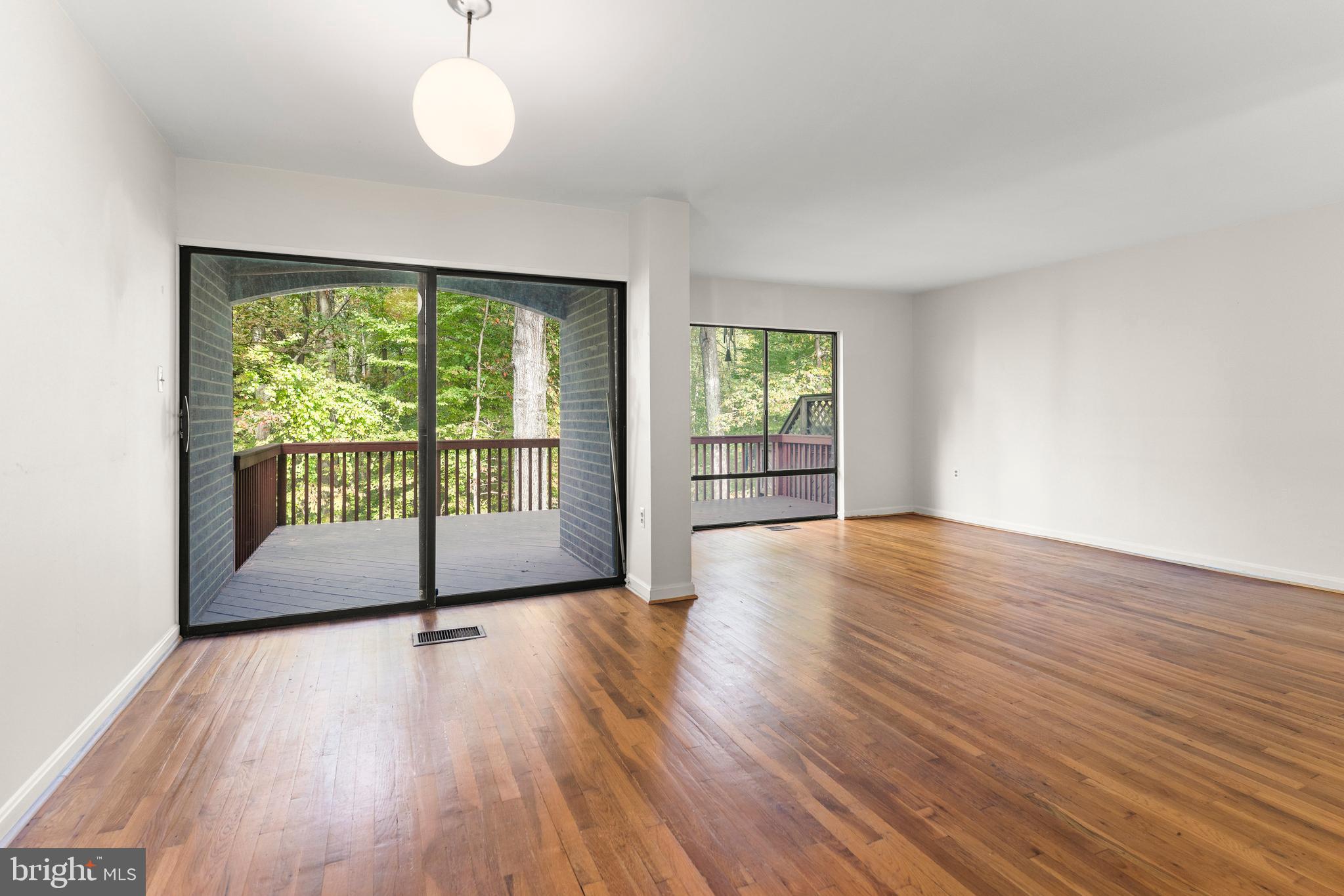 7911 Inverness Ridge Road Potomac, MD 20854 - Photo 12 of 45 an empty room with wooden floor and windows