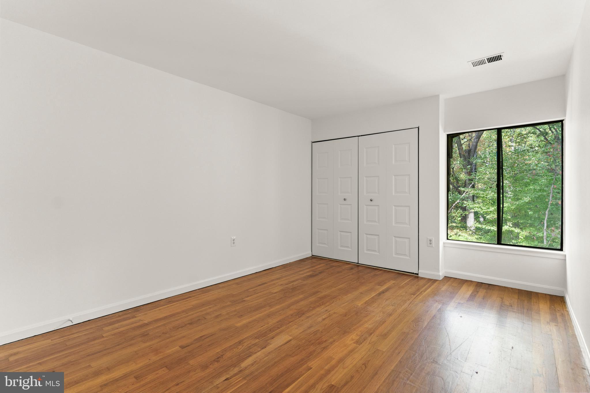 7911 Inverness Ridge Road Potomac, MD 20854 - Photo 13 of 45 a view of an empty room with wooden floor and a window
