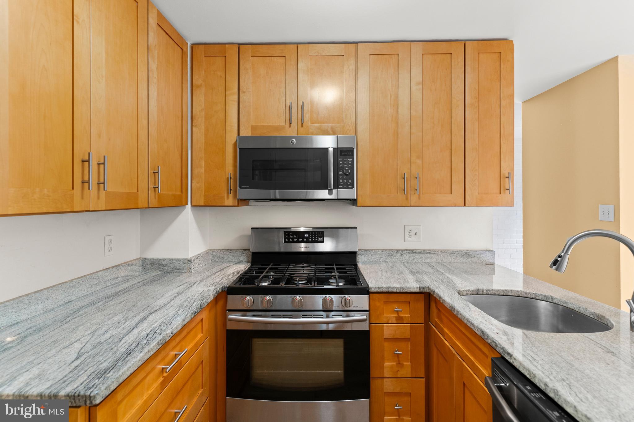 7911 Inverness Ridge Road Potomac, MD 20854 - Photo 4 of 45 a kitchen with granite countertop wood cabinets stainless steel appliances and a sink