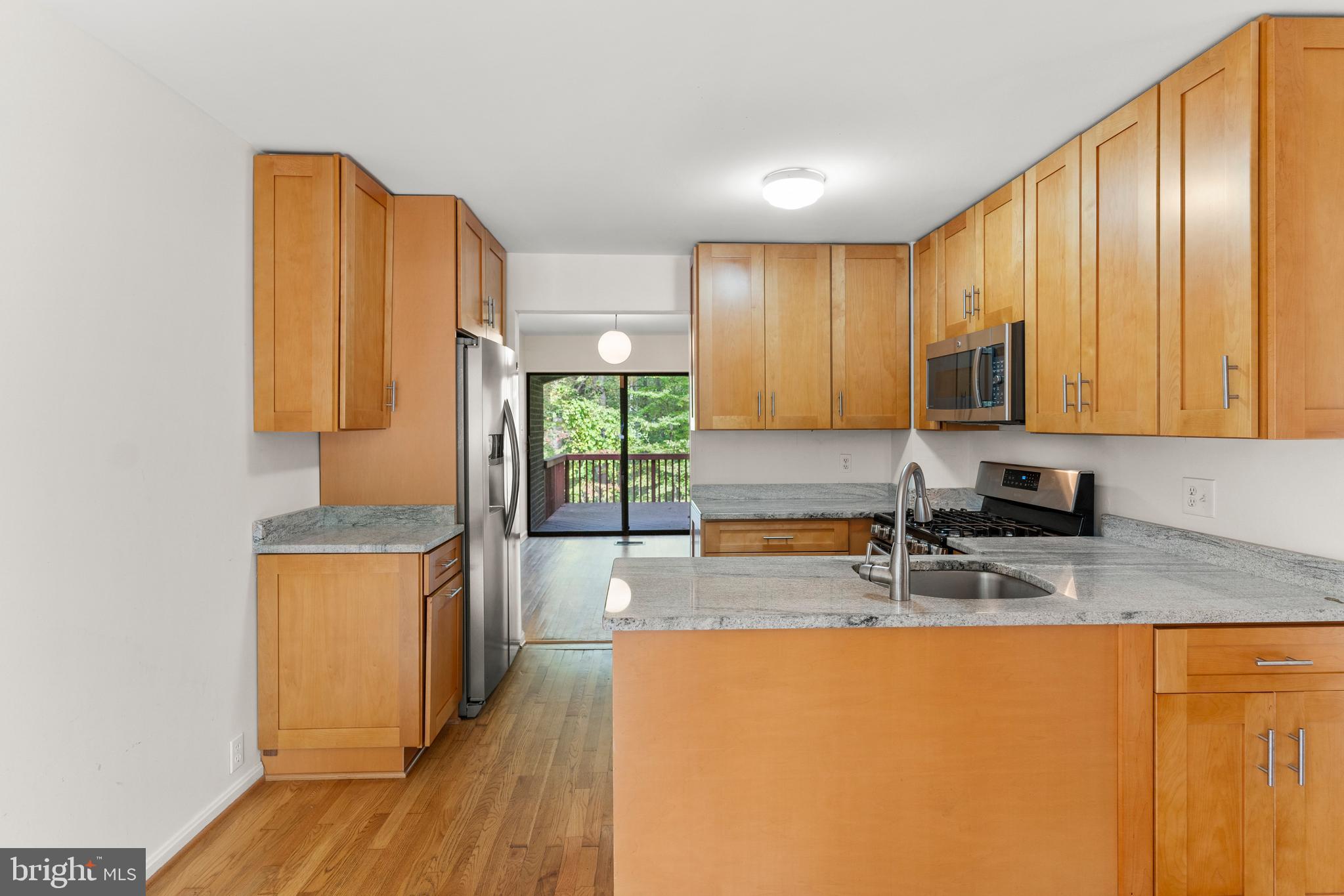 7911 Inverness Ridge Road Potomac, MD 20854 - Photo 5 of 45 a kitchen with stainless steel appliances granite countertop wooden floors a stove top oven a sink and dishwasher