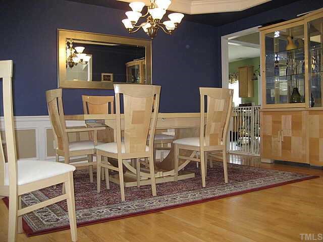 7552 Silver View Lane Raleigh, NC 27613 - Photo 2 of 10 a dining room with wooden floor a chandelier a glass table and chairs
