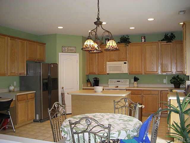 7552 Silver View Lane Raleigh, NC 27613 - Photo 3 of 10 a room with a table chairs and a refrigerator