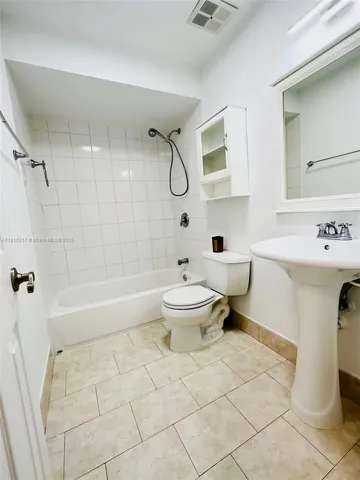 a bathroom with a toilet sink and shower