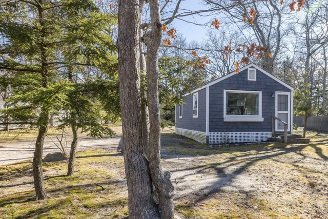 a view of a house with a yard tree and wooden fence