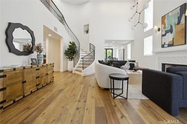 a living room with furniture a mirror and a wooden floor