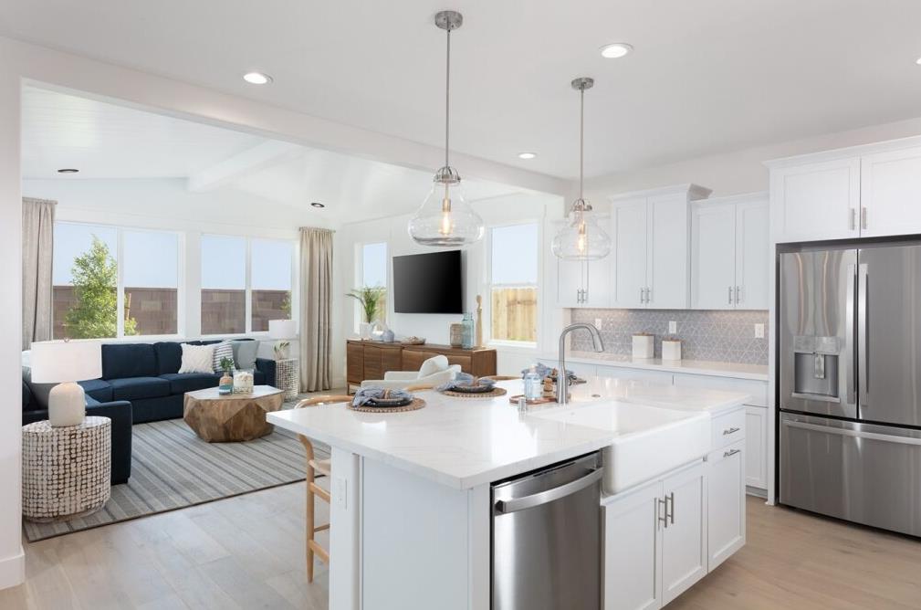4424 Canyon Coral Way Rancho Cordova, CA 95742 - Photo 4 of 12 a kitchen with stainless steel appliances kitchen island granite countertop a sink refrigerator and cabinets