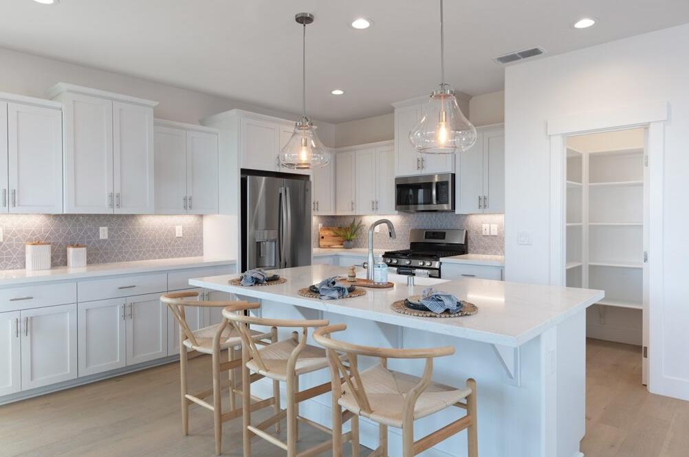 4424 Canyon Coral Way Rancho Cordova, CA 95742 - Photo 6 of 12 a kitchen with kitchen island granite countertop a sink stove and refrigerator