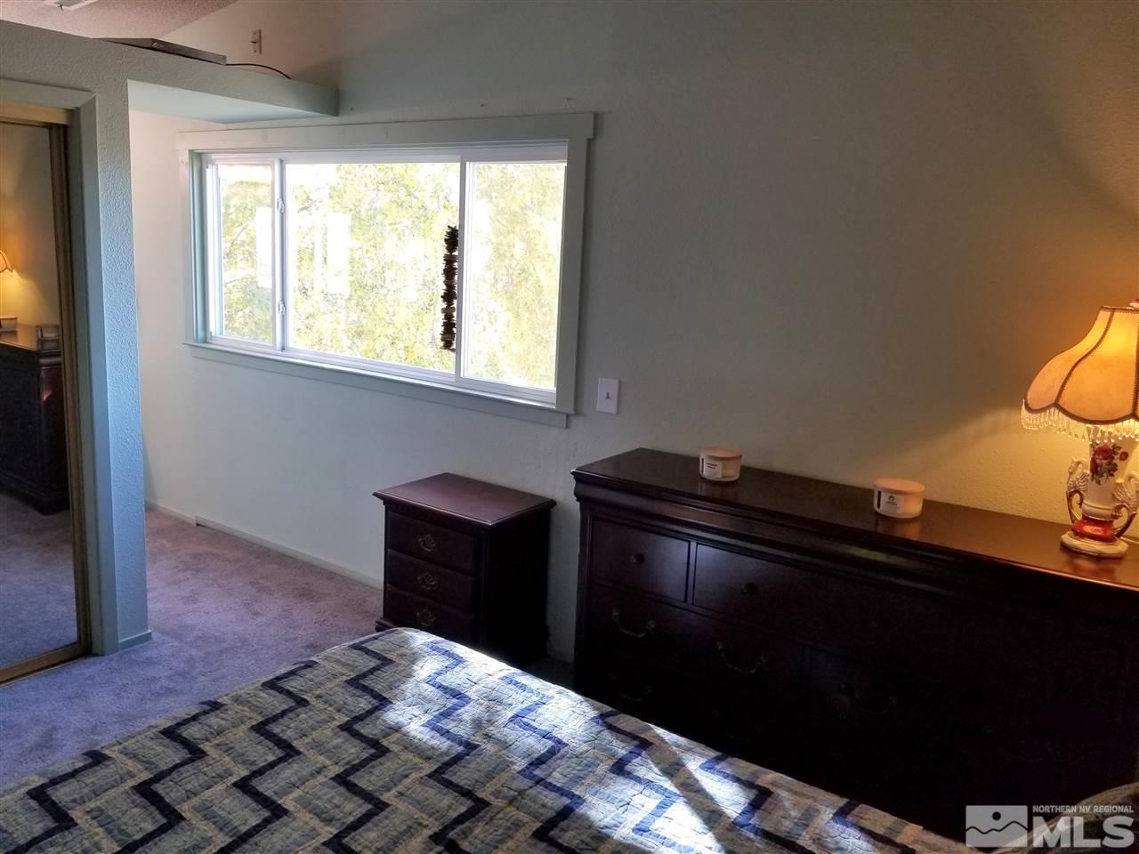 7135 Indigo Circle Reno, NV 89506 - Photo 14 of 21 a bed sitting in a bedroom next to a window