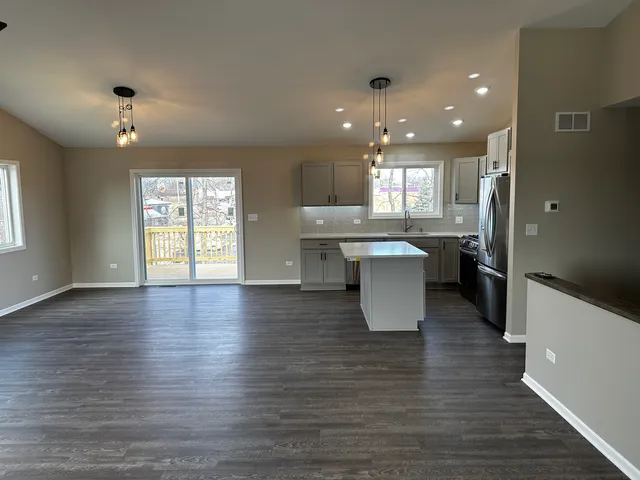 an open kitchen with kitchen island white cabinets and stainless steel appliances