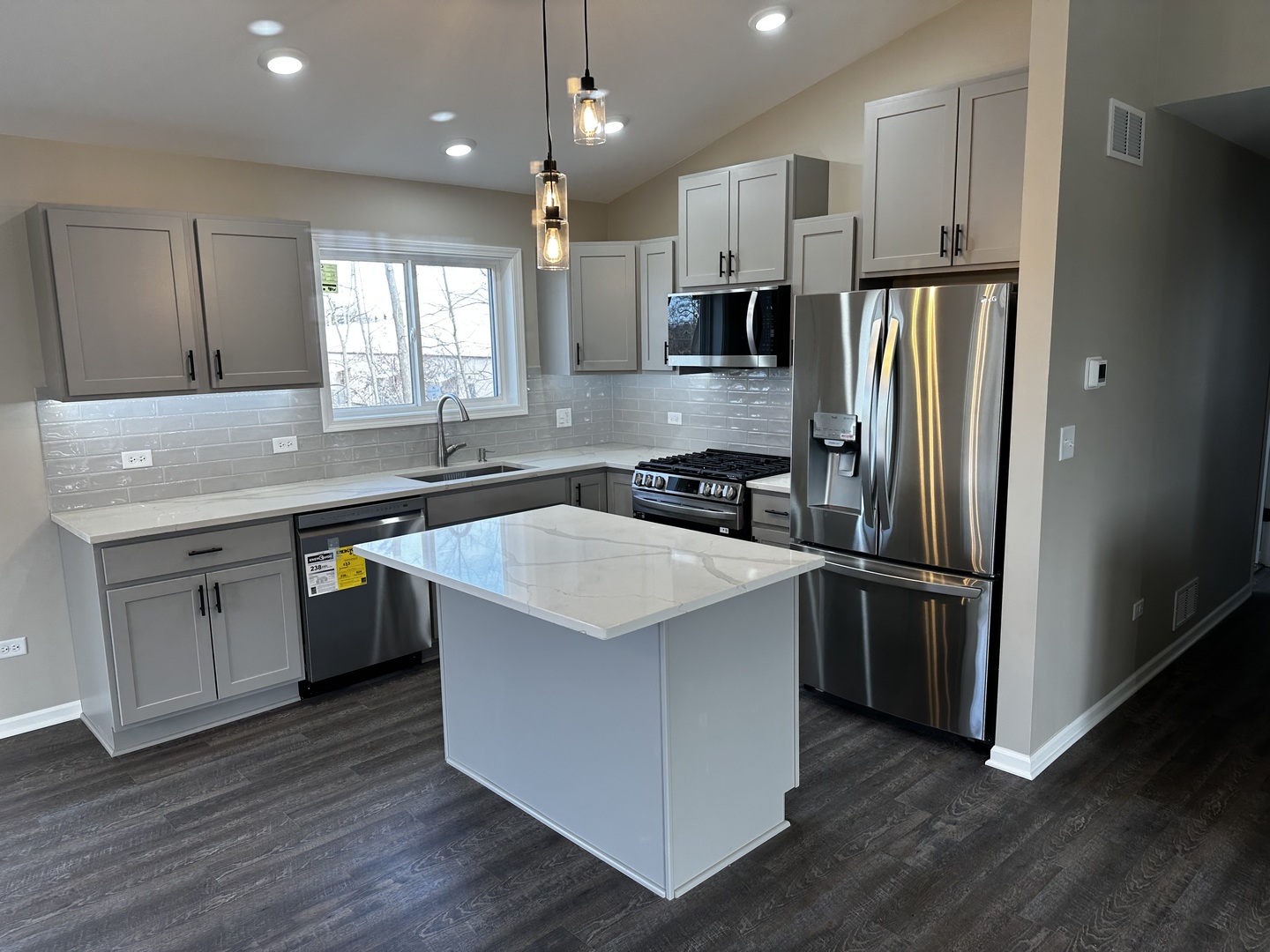 317 Buena Terrace Antioch, IL 60002 - Photo 5 of 10 a kitchen with stainless steel appliances granite countertop a sink a refrigerator a stove a microwave and island with wooden floor