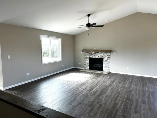 an empty room with windows and fireplace