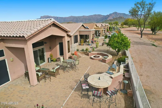 a view of a patio with couches table and chairs under an umbrella