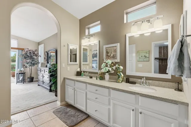 a spacious en suite bathroom with double sink and a mirror