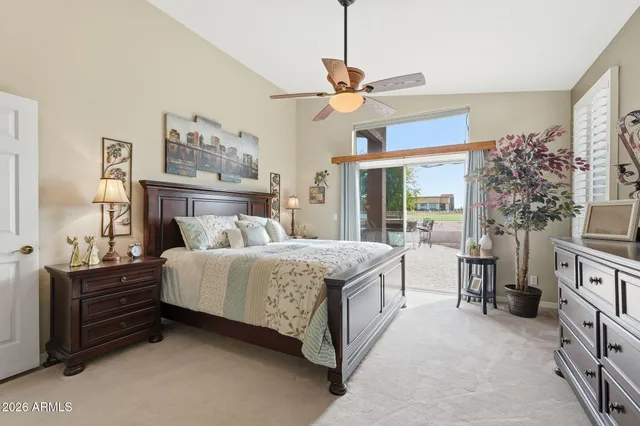 a bedroom with a bed dresser and a chandelier