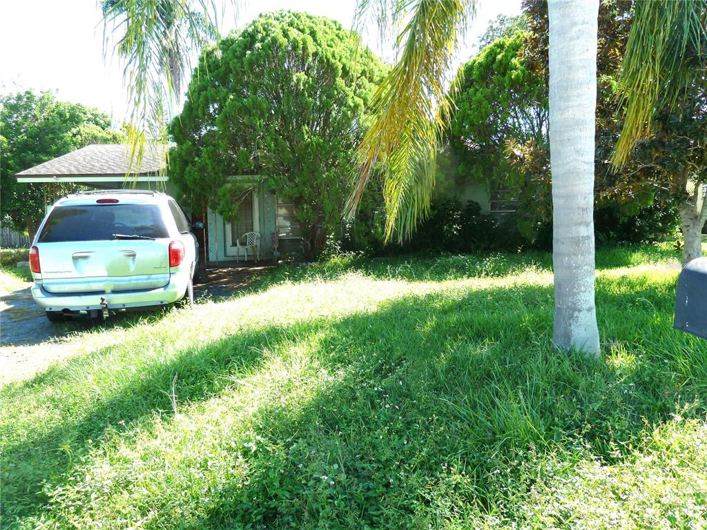a front view of a house with a yard and trees