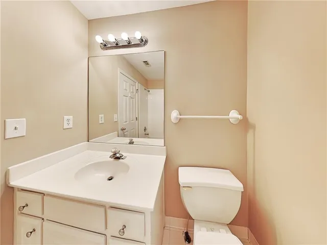 a bathroom with a sink a toilet a mirror and vanity