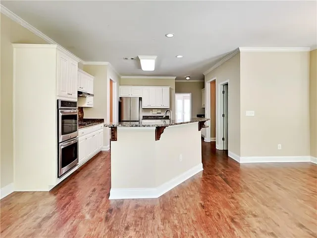 a view of kitchen with microwave a refrigerator and cabinets