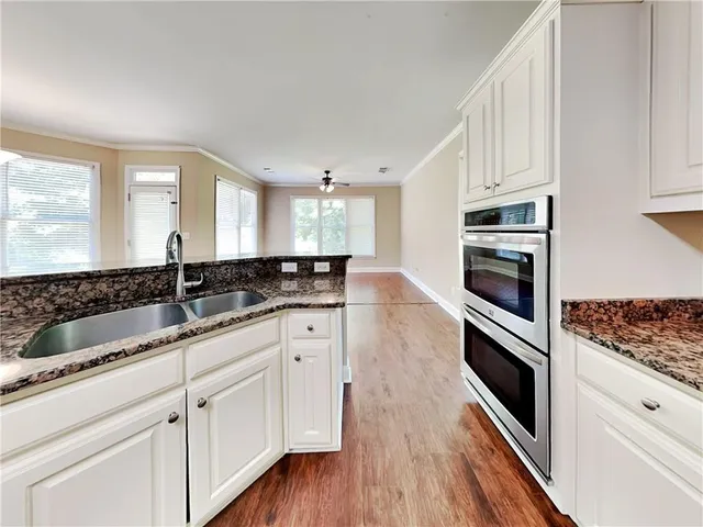 a kitchen with granite countertop white cabinets and white appliances