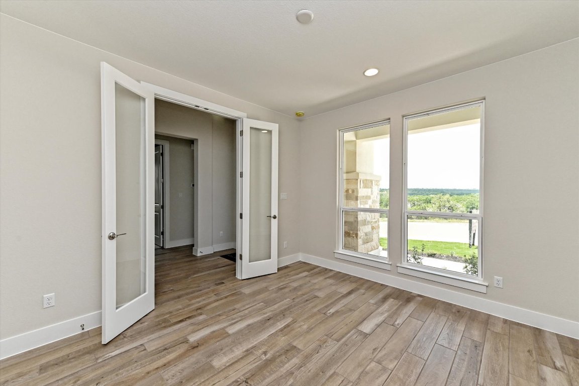1221 Stormy Drive Georgetown, TX 78628 - Photo 13 of 33 a view of an empty room with wooden floor and a window