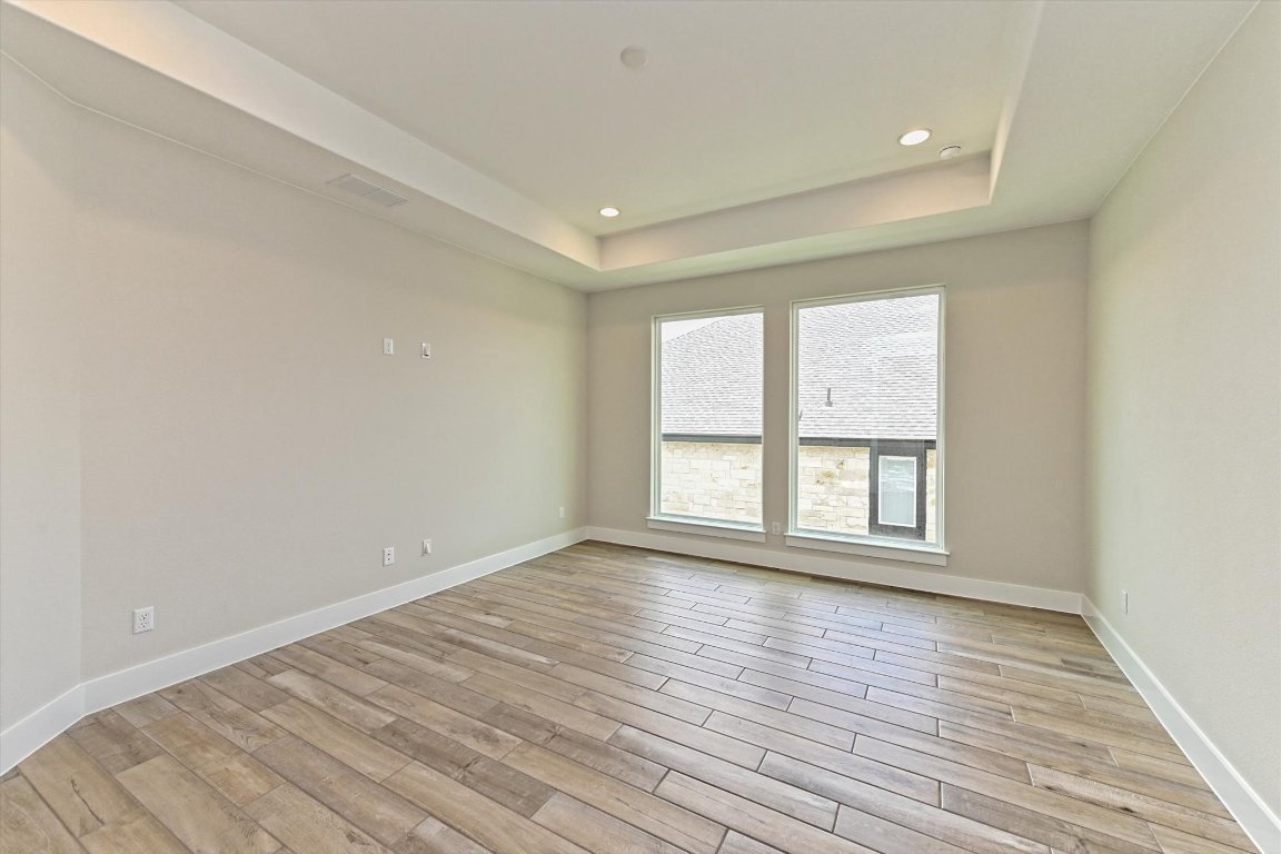 1221 Stormy Drive Georgetown, TX 78628 - Photo 14 of 33 wooden floor in an empty room with a window