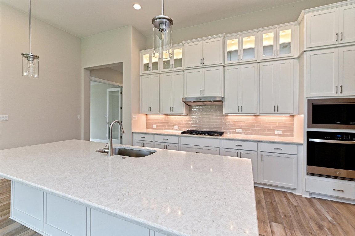 1221 Stormy Drive Georgetown, TX 78628 - Photo 3 of 33 a kitchen with kitchen island granite countertop a sink cabinets and stainless steel appliances
