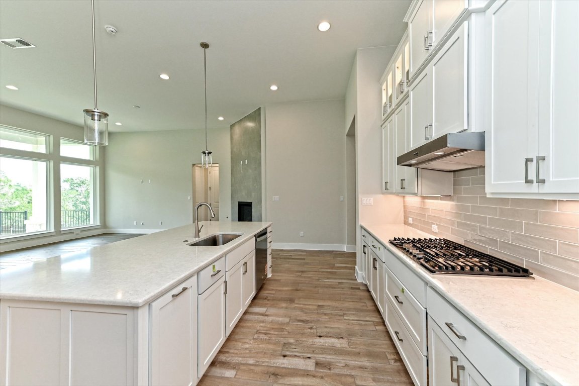 1221 Stormy Drive Georgetown, TX 78628 - Photo 4 of 33 a kitchen with kitchen island a sink stove and cabinets