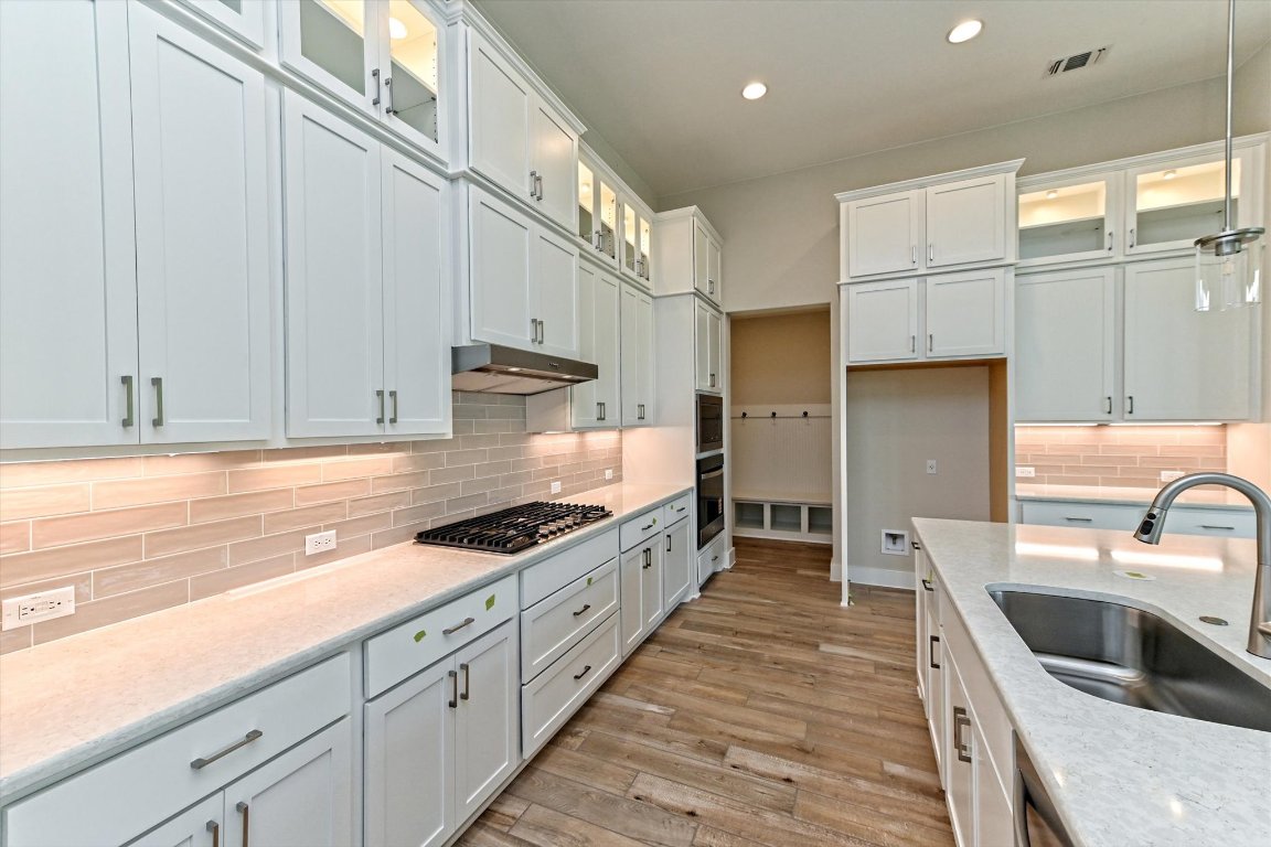 1221 Stormy Drive Georgetown, TX 78628 - Photo 5 of 33 a kitchen with granite countertop a sink a counter space stainless steel appliances and cabinets