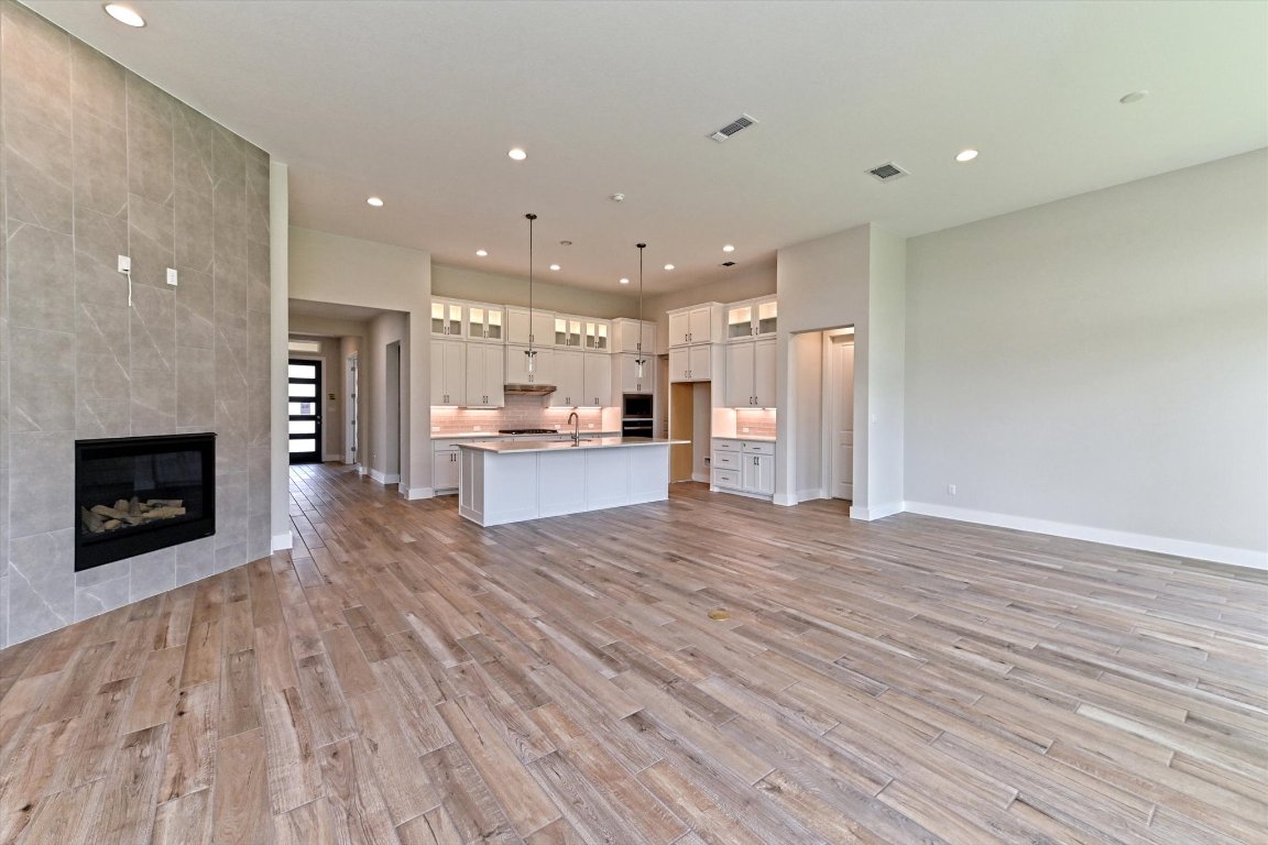 1221 Stormy Drive Georgetown, TX 78628 - Photo 8 of 33 a view of kitchen with kitchen island wooden floor and a fireplace