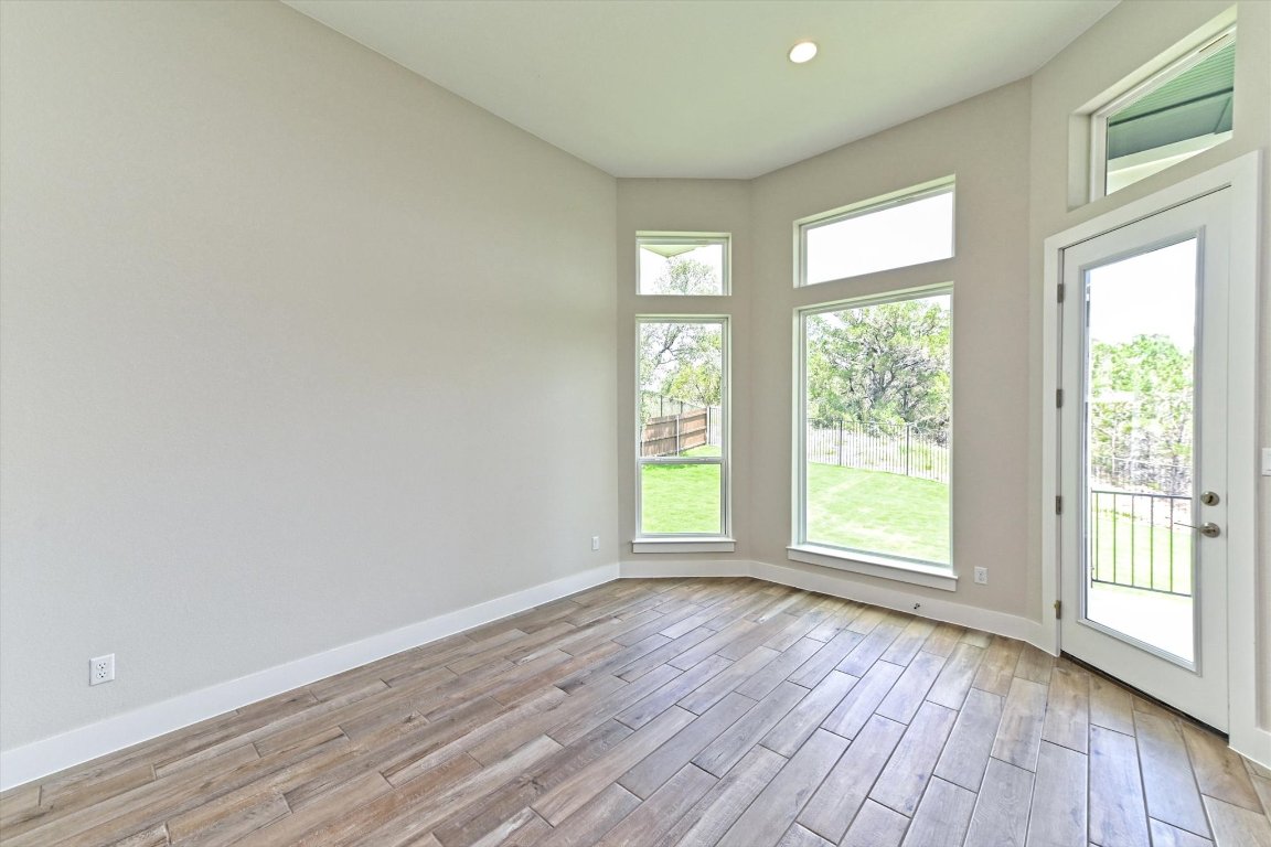 1221 Stormy Drive Georgetown, TX 78628 - Photo 10 of 33 a view of an empty room with wooden floor and a window