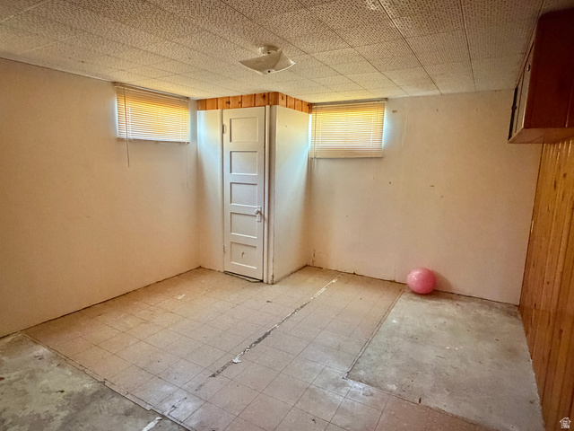 196 North 5th West Price, UT 84501 - Photo 18 of 27 Room featuring a paneled interior door, two windows with blinds, wood paneling accents, and a textured ceiling