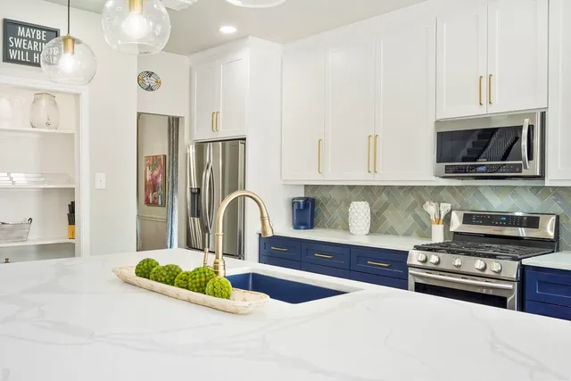 a kitchen with stainless steel appliances granite countertop a stove a sink and a microwave