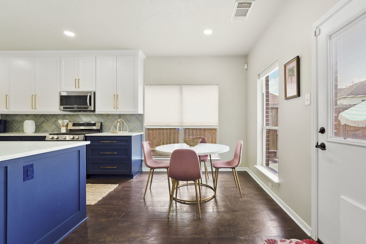 8615 Discus Drive Humble, TX 77346 - Photo 15 of 50 a kitchen with stainless steel appliances granite countertop a stove top oven a sink a dining table and chairs with wooden floor
