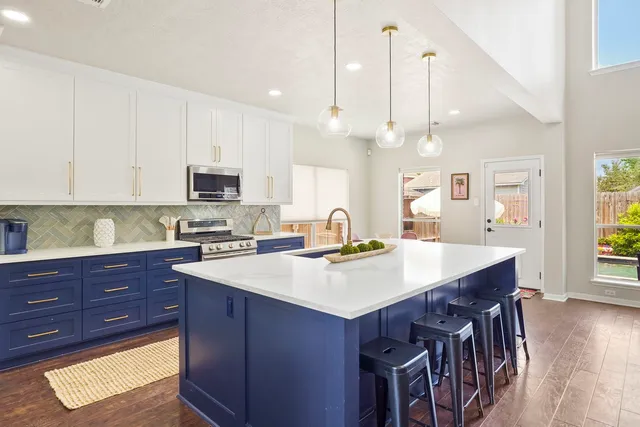 a kitchen with a stove a sink a dining table and chairs