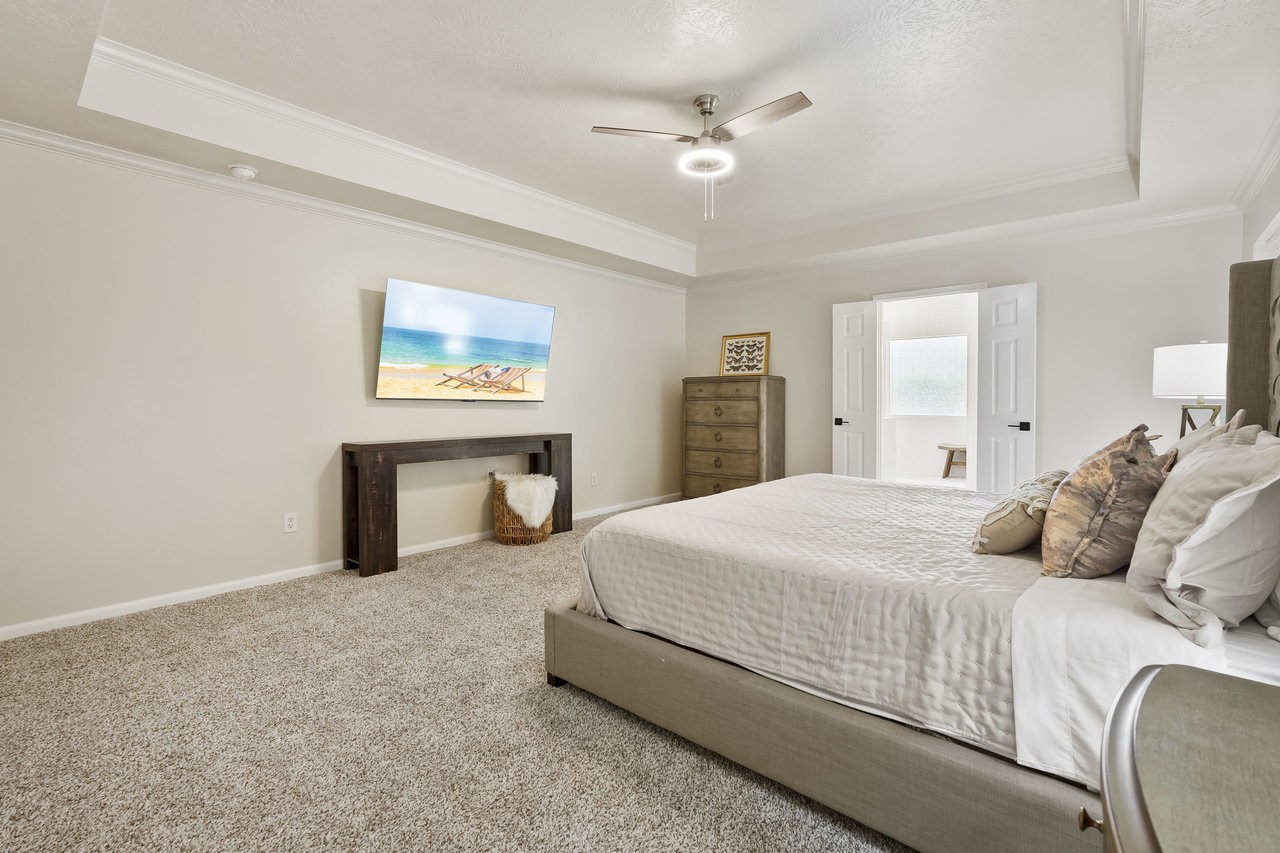 8615 Discus Drive Humble, TX 77346 - Photo 27 of 50 a bedroom with a large bed and a chandelier