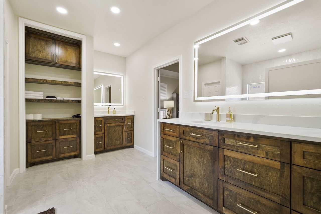 8615 Discus Drive Humble, TX 77346 - Photo 31 of 50 a spacious bathroom with a double vanity sink a large mirror and a bathtub