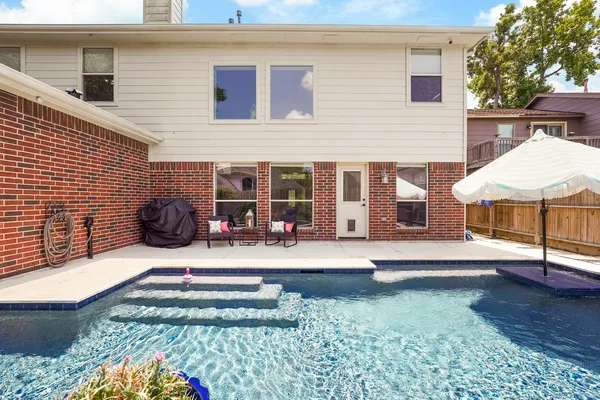 a view of a house with backyard and sitting area