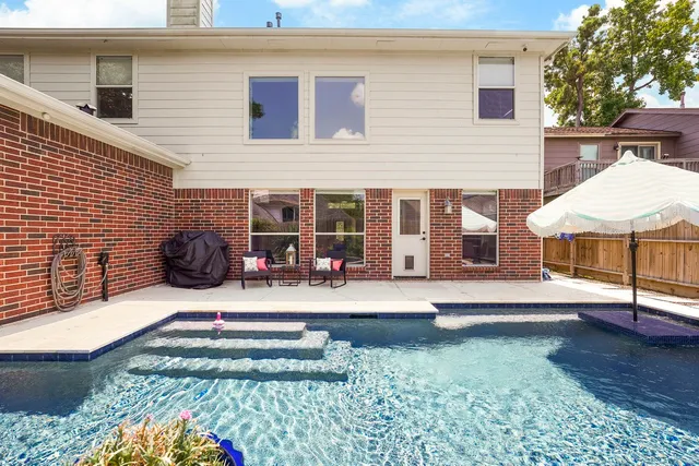 a view of a house with backyard and sitting area