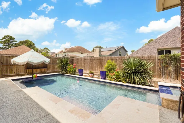 a view of a house with pool and chairs
