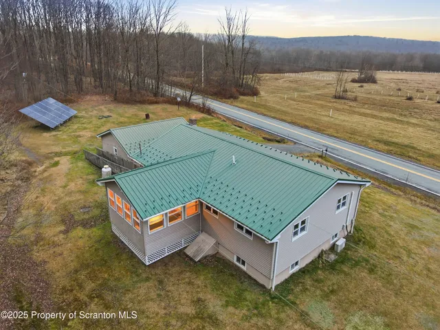 a view of a pool with a bench and lawn chairs
