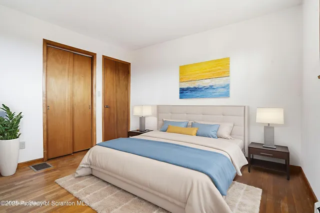 a bedroom with a bed and a potted plant