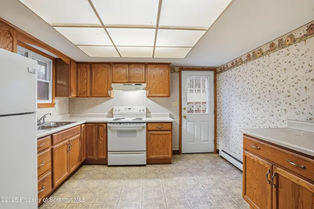 a kitchen with a stove refrigerator sink and cabinets