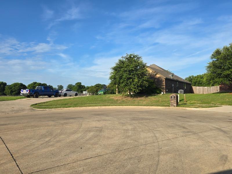104 Anthony Lane Red Oak, TX 75154 - Photo 2 of 6 Brick-clad residence featuring a gabled roofline, mature landscaping, and a wooden privacy fence